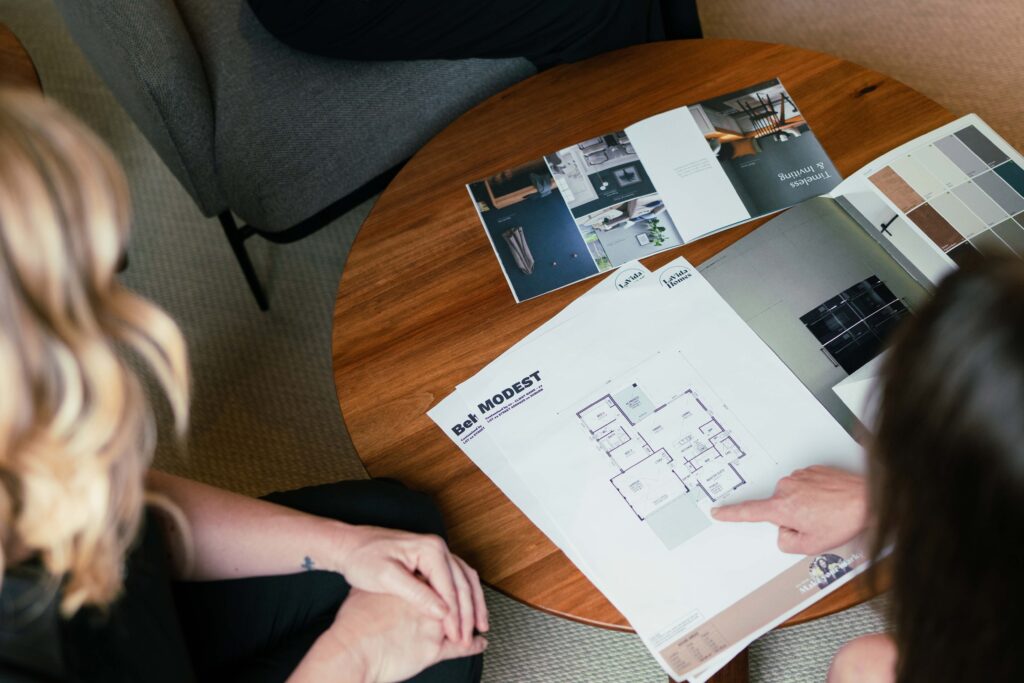 The House and Land Co team presents custom home designs to a buyer